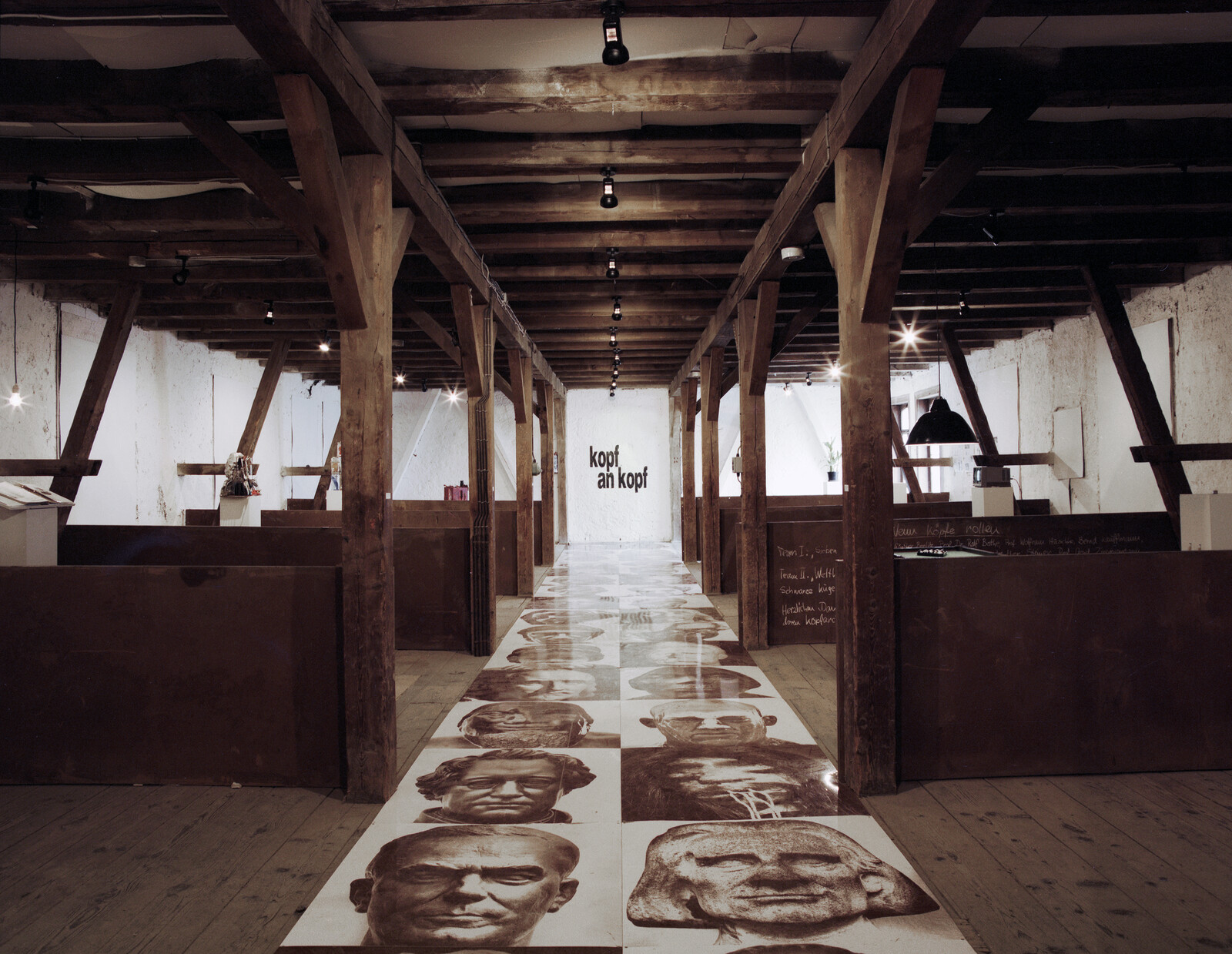 Ausstellungsansicht mit historischen Köpfen und zehn Kunstnischen, in denen früher Getreide gelagert wurde, 1996.